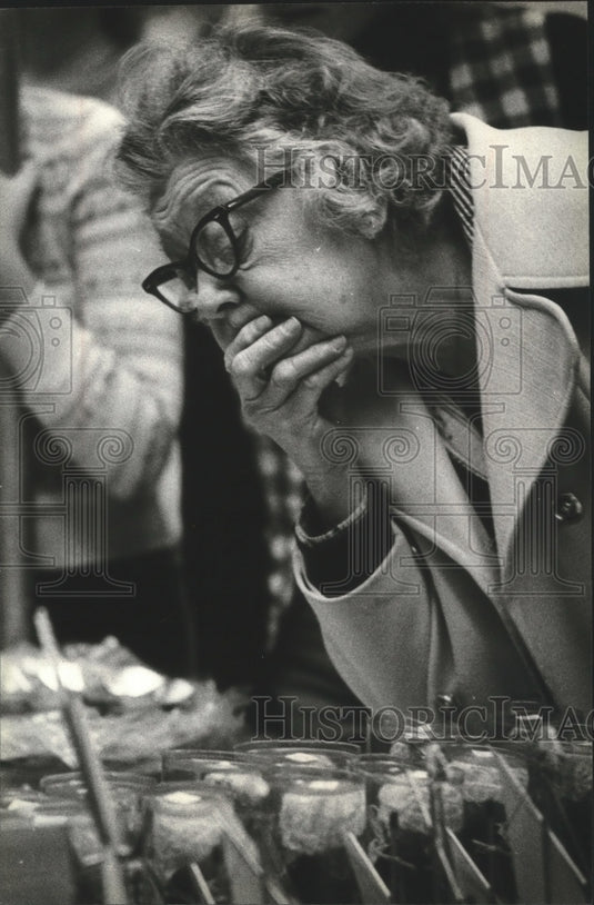 1979 Press Photo Viola Sanderson studying dolls from Holland at Folk Fair-Historic Images