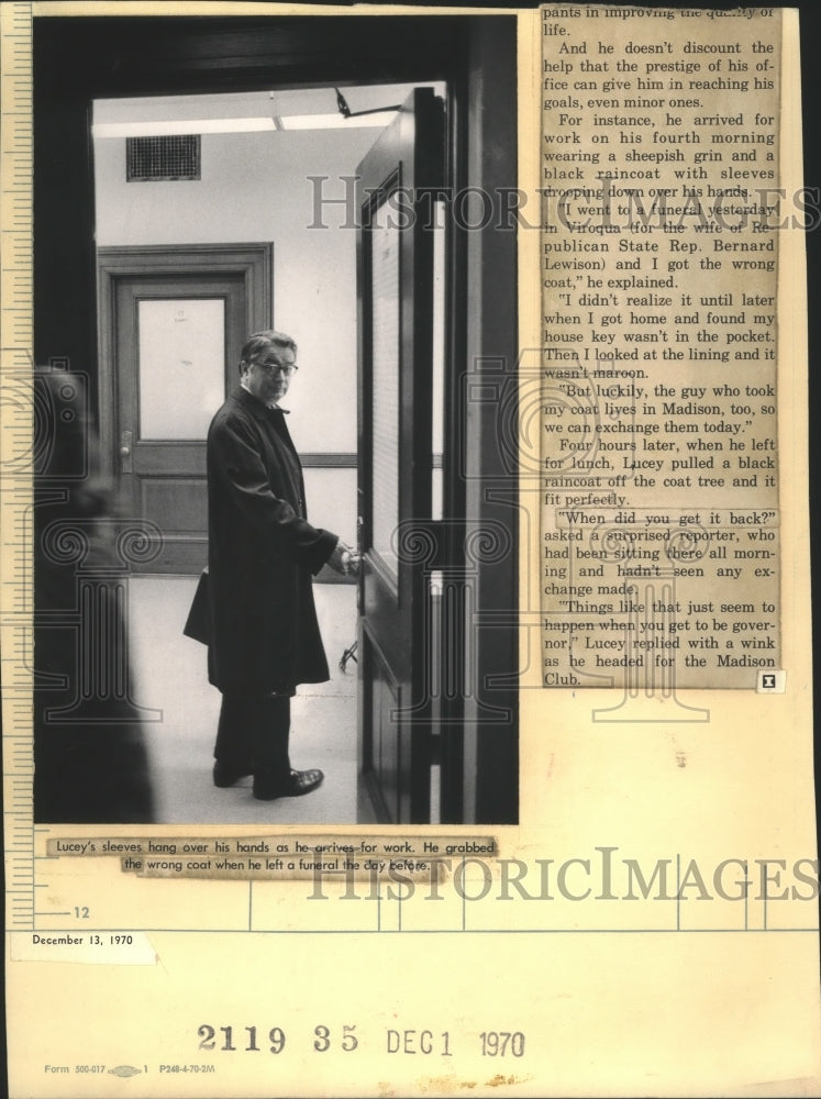 1970 Press Photo Patrick Lucey arrives for work in oversized coat - Historic Images