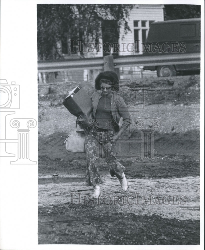 1968 Press Photo Deanna Keys crosses muddy area left by flood, Fairbanks, Alaska - Historic Images