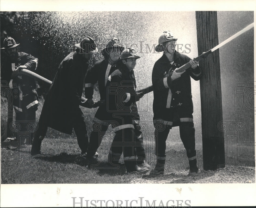 1983 Press Photo Waukehsha fire fighters handle hose in local competition - Historic Images