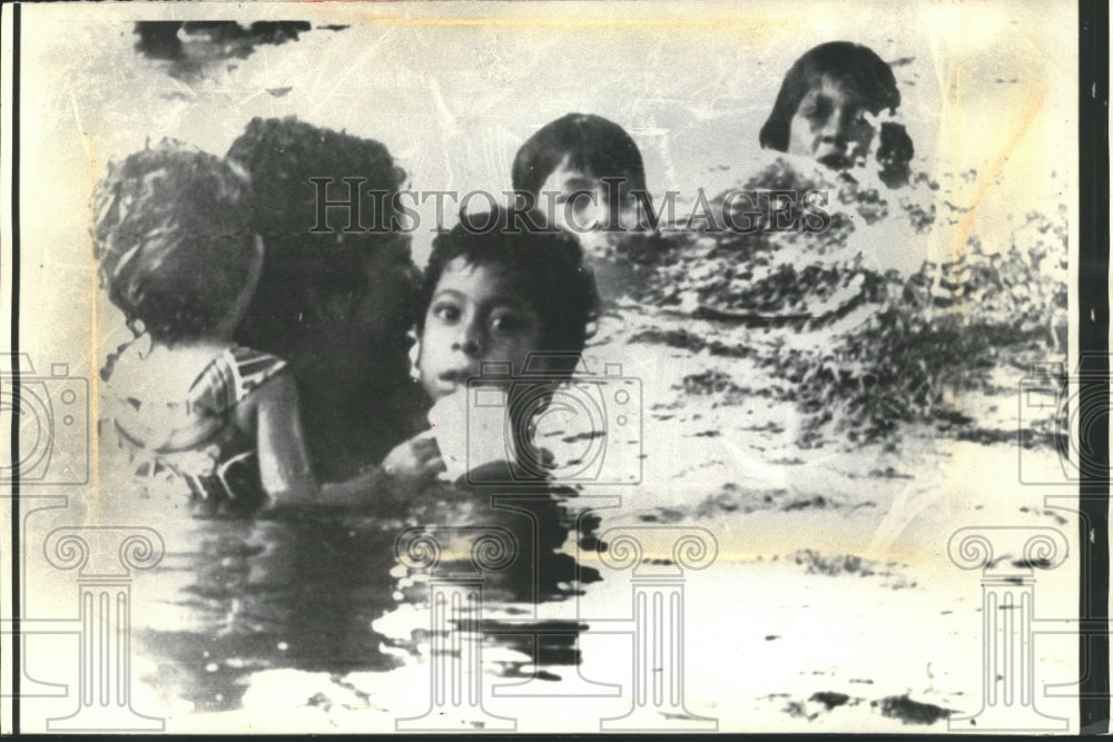 1976 Press Photo A desperate family wades in floodwaters near Tampico, Mexico - Historic Images