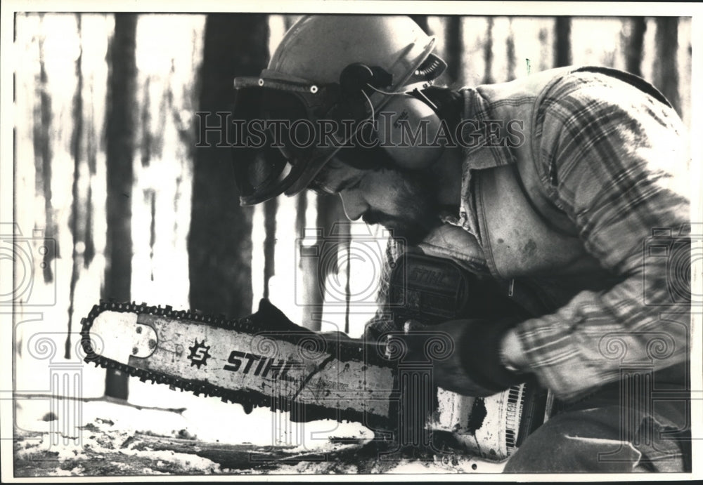 1988 Press Photo Lumberjack Durrell Houghtaling Sharpens Chainsaw, Pennsylvania - Historic Images