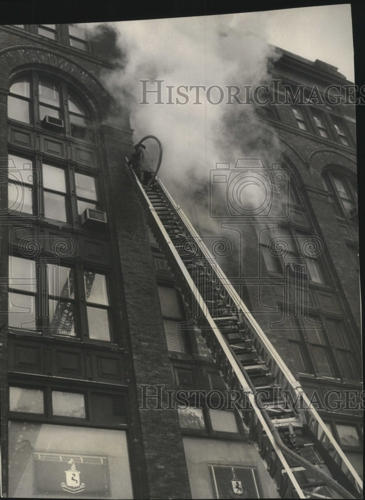 1957 Press Photo Fireman climbs to battle fire at Patton building, Milwaukee - Historic Images