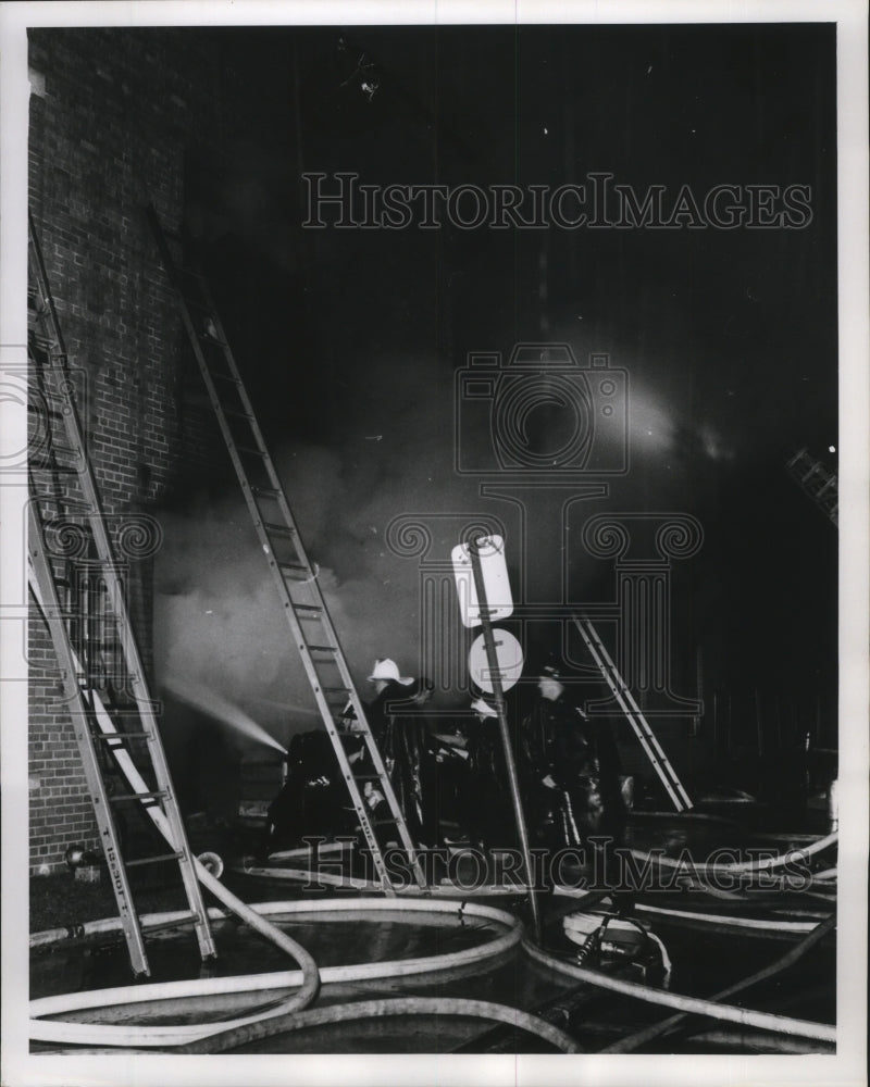 1960 Press Photo Firemen fight Building Fire in Rain in Milwaukee, Wisconsin - Historic Images