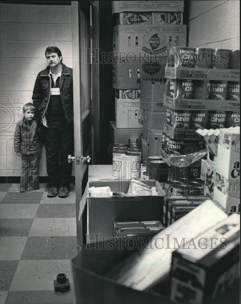 1984 Press Photo A man and son wait to receive food from a food bank - Historic Images