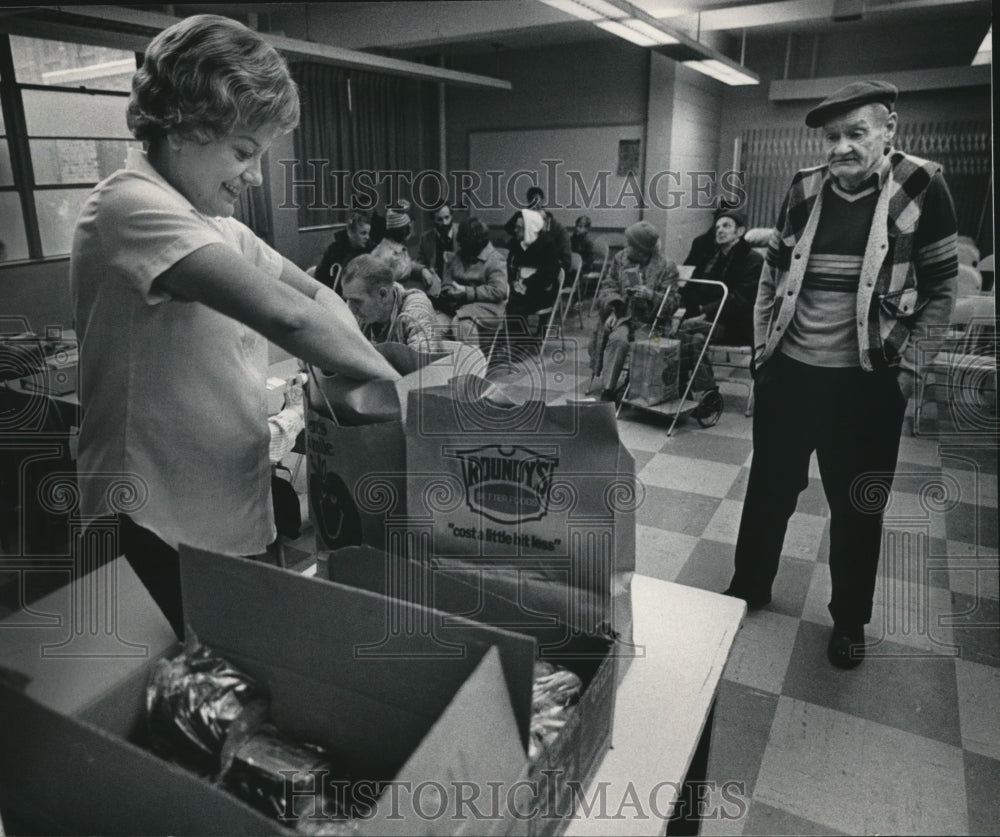 1984 Press Photo Carol Young packed a sack of food at Interchange Food Pantry - Historic Images