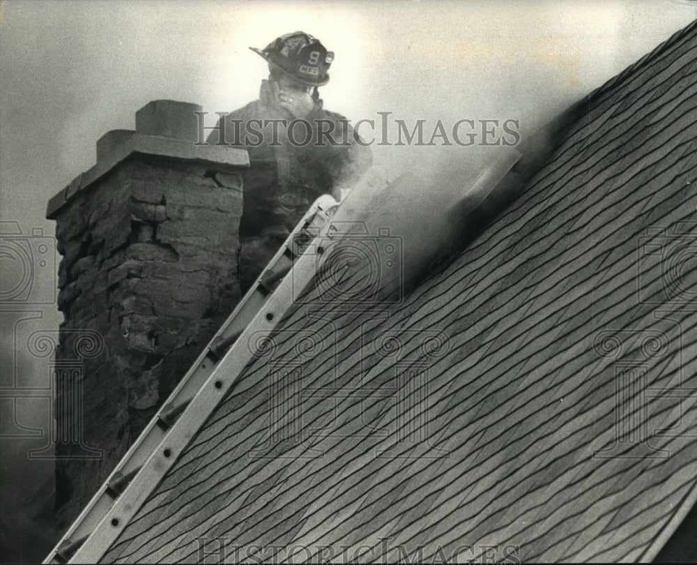 1991 Press Photo Milwaukee Firefighter on Roof of a House during Fire - Historic Images