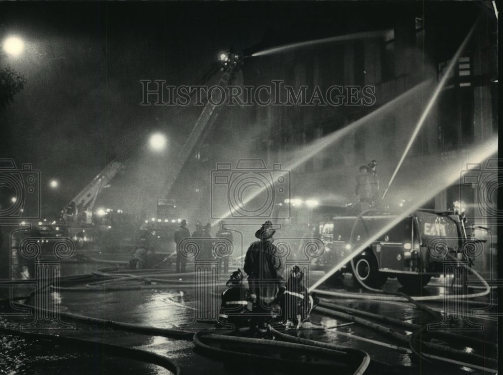 1986 Press Photo Milwaukee firefighters battle a suspicious blaze in heavy rain - Historic Images