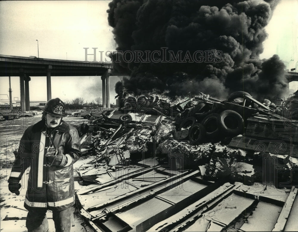 1988 Press Photo Burning tires and debris behind Vehicle Towing in Milwaukee - Historic Images