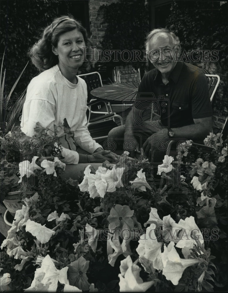 1991 Kathleen Byrnes and husband, relaxing on patio by their garden.-Historic Images