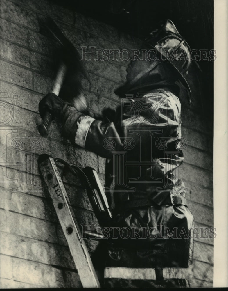 1986 Press Photo Firefighter Swings Ax while Battling Milwaukee Blaze - Historic Images