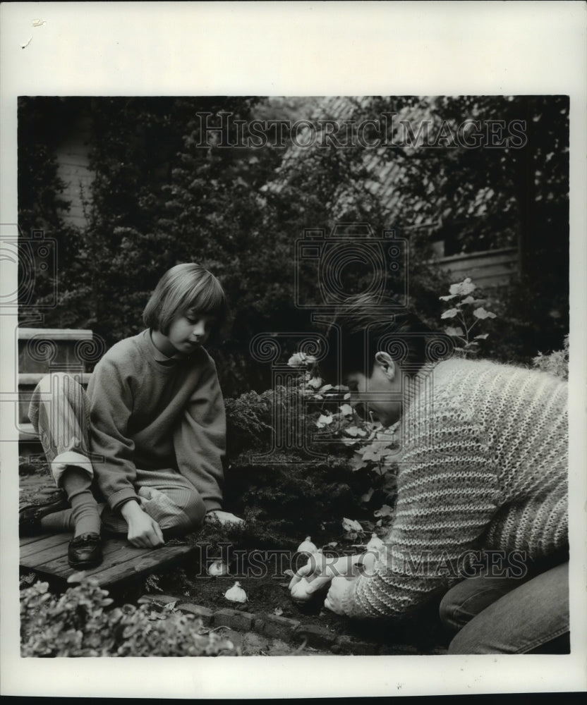 1986 Press Photo Mother and Daughter plant bulbs in Garden in Autumn - mjb18441 - Historic Images