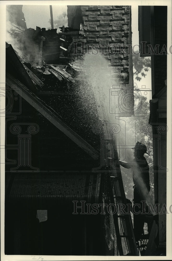1987 Press Photo Firefighters hose down the roof of a home on Fond du Lac Ave. - Historic Images