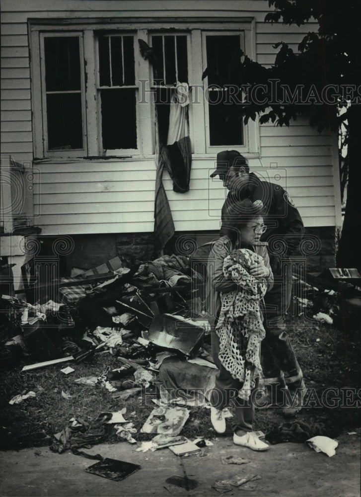 1987 Press Photo Rosella Ramthun recovers blanket from home after fire - Historic Images