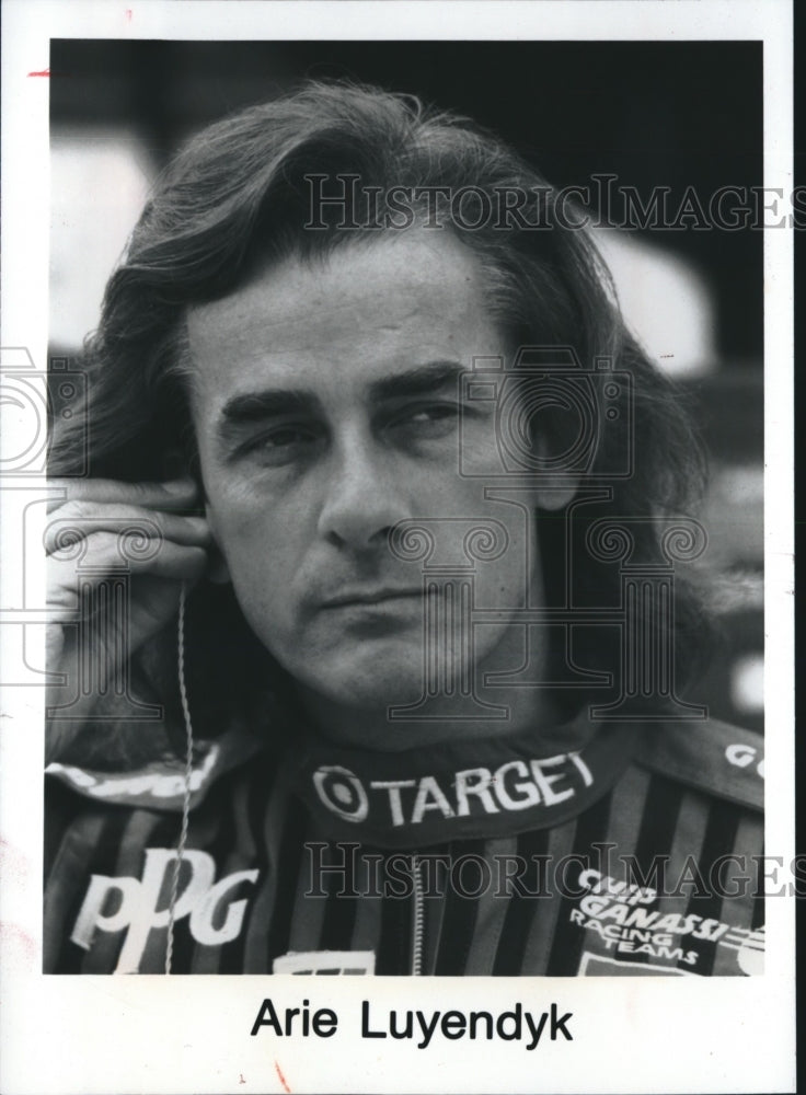 1993 Press Photo Arie Luyendyk, race car driver, preparing ear phone for race - Historic Images