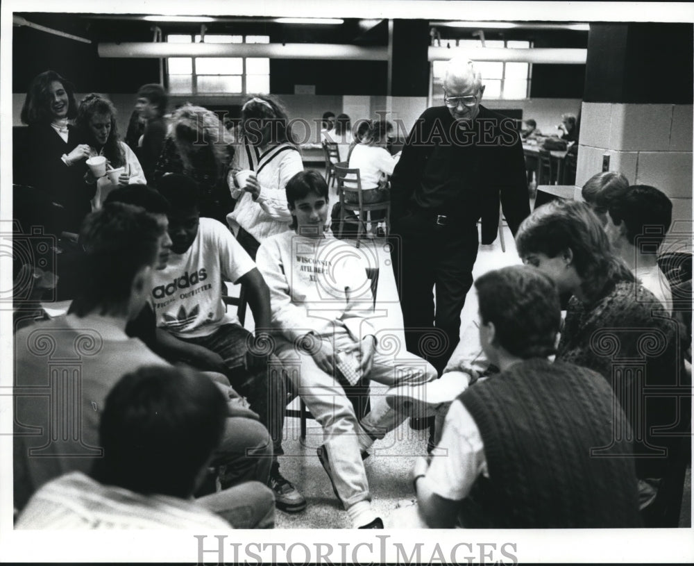 1990 Press Photo Father McCall talks with students at Pius XI High School. - Historic Images