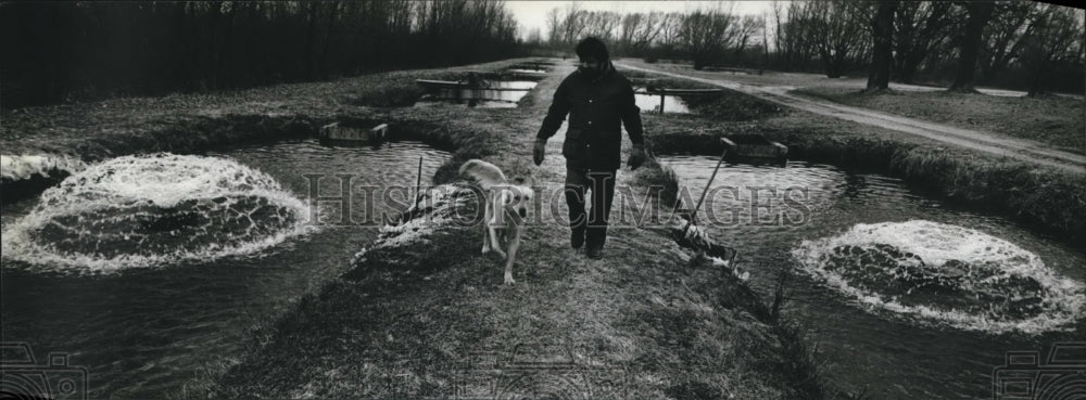 1983 Press Photo Yanzito Walks Along Dike Between Fish-Raising Ponds - mjb20508 - Historic Images