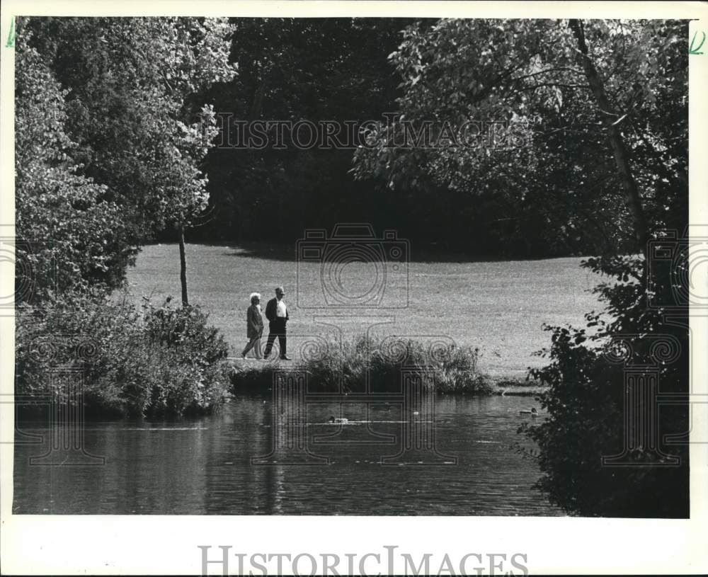 1981 Press Photo A couple walks along lagoon in Greenfield Park in West Allis - Historic Images