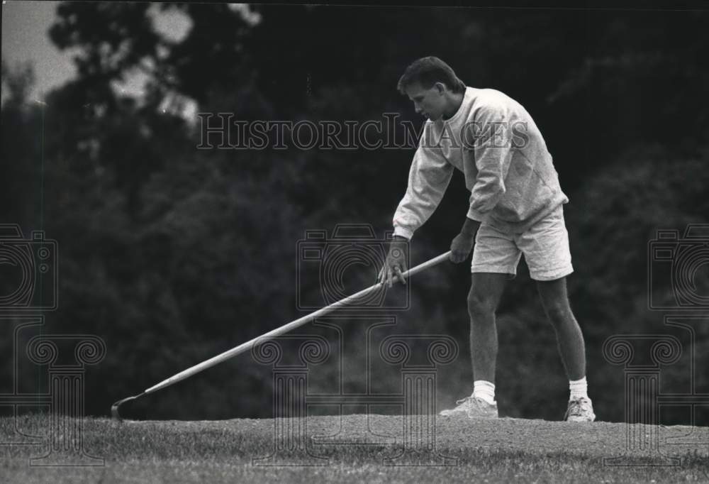 1992 Press Photo Scott Theado rakes dirt at Greenfield Park in West Allis - Historic Images