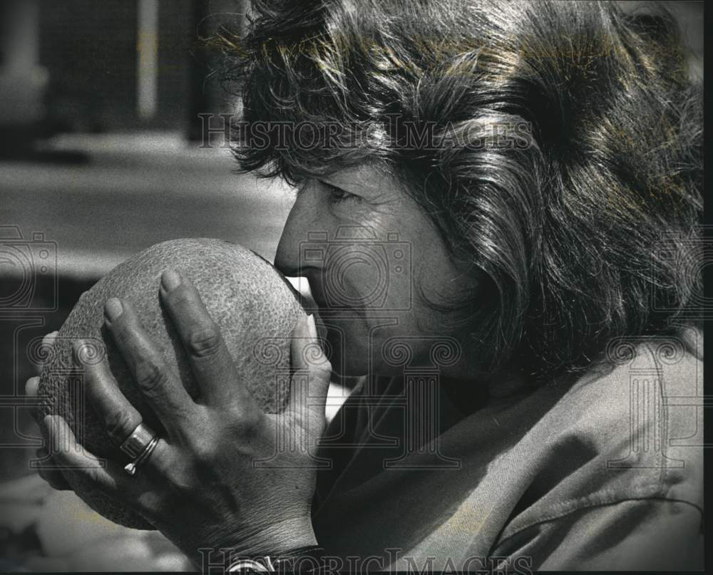 1992 Press Photo Nancy Brilloult sniffs a cantaloupe at the Fruitables stand - Historic Images