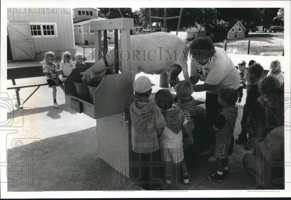 1994 Press Photo Guide milking a goat in front of kids at Green Meadows Farm - Historic Images