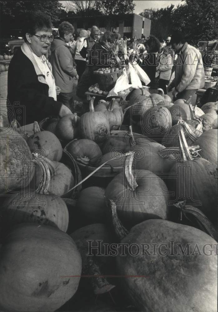 1991 Press Photo Kathy Feuling browses pumpkins at Green Market, Milwaukee WI - Historic Images