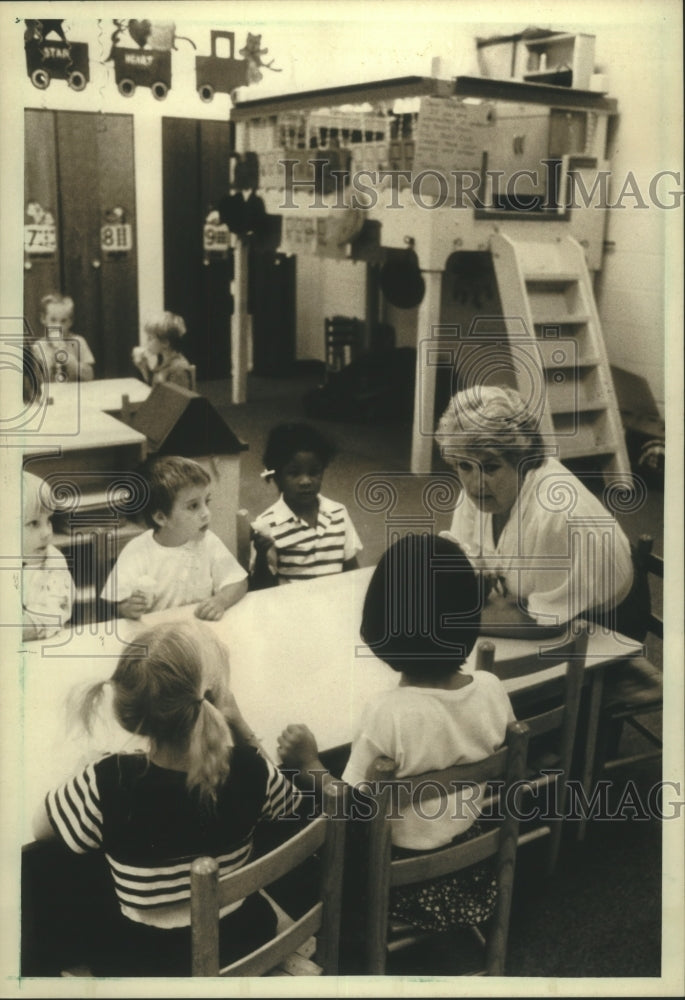 1989 Press Photo Jean Weber, teacher, works with kids at Marquette Electronics. - Historic Images