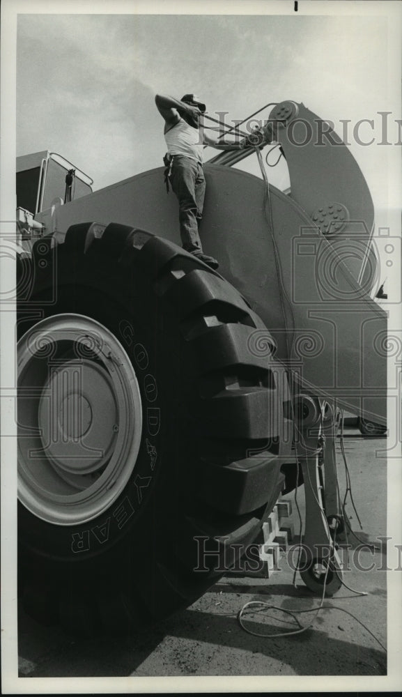 1983 Press Photo Man Works on Large Front Loader with Huge Tires - Historic Images