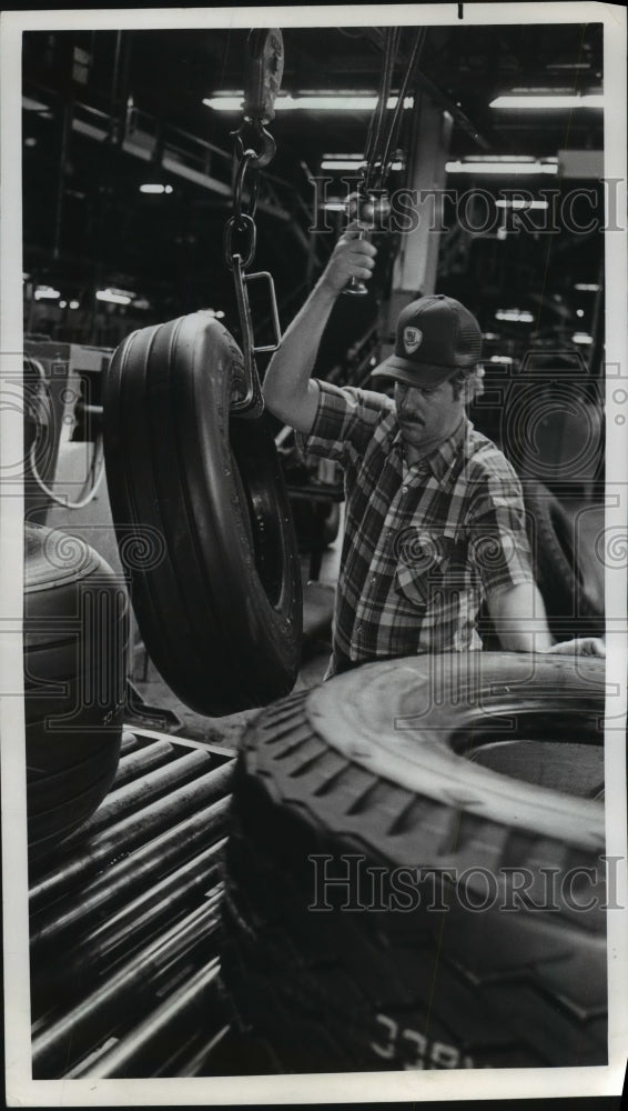 1982 Press Photo Goodyear Employee Lifts Aircraft Tire for Visual Inspection - Historic Images
