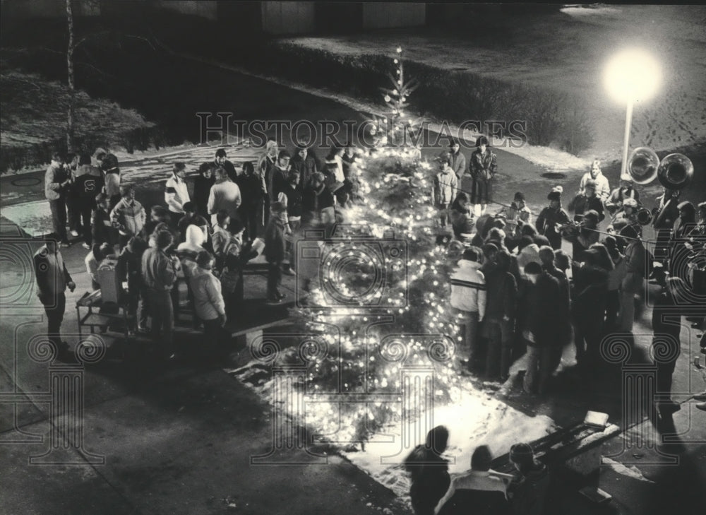 1983 Press Photo Caroling Marquette University Students near Lit Christmas Tree - Historic Images
