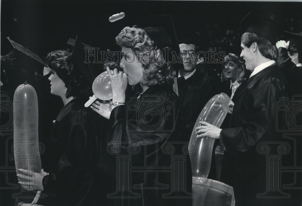 1986 Press Photo Marquette University Business Graduates Blow up Balloons - Historic Images