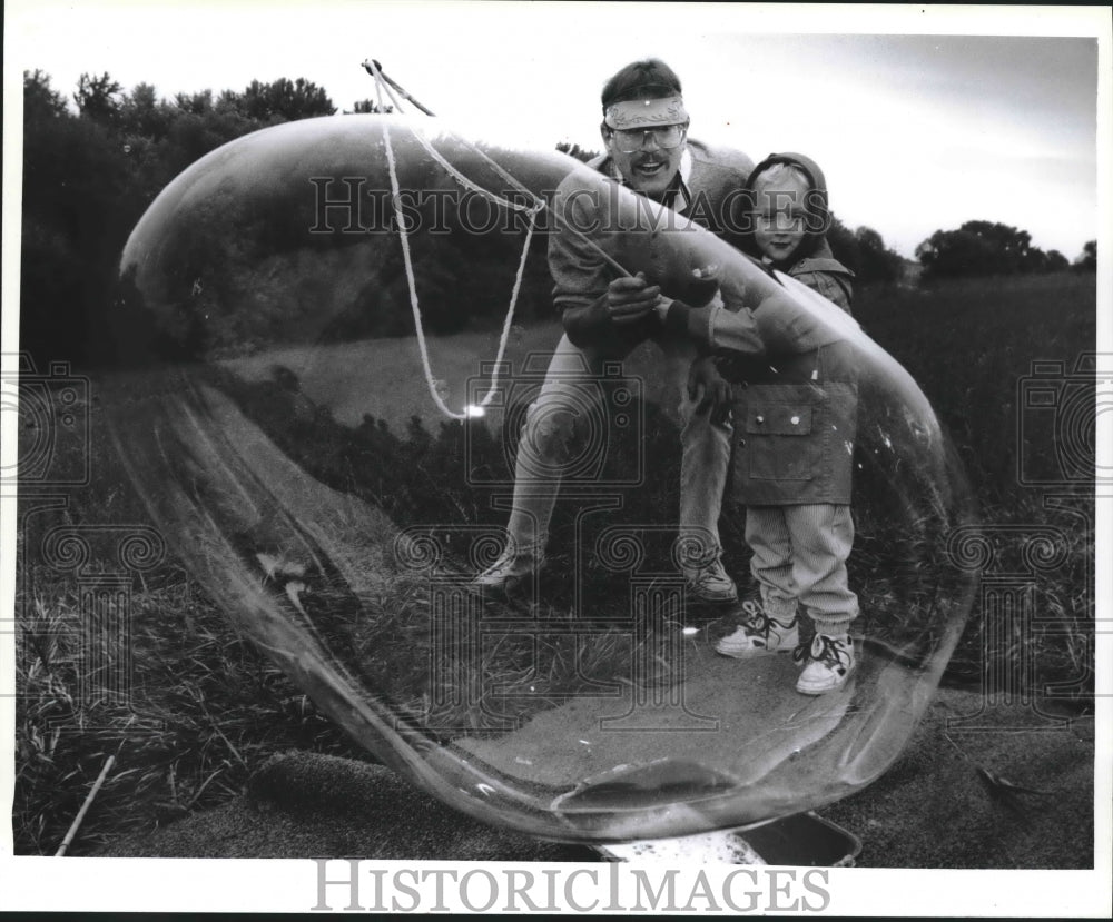 1993 Press Photo &quot;Mr. Bubbles,&quot; helps Tyler Tuescher create a giant bubble - Historic Images