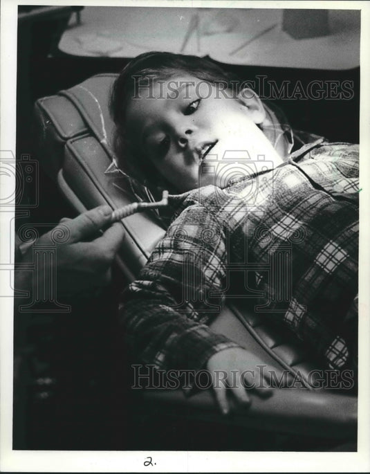 1983 Press Photo Mike Sutheimer examines a dental instrument before it is used. - Historic Images