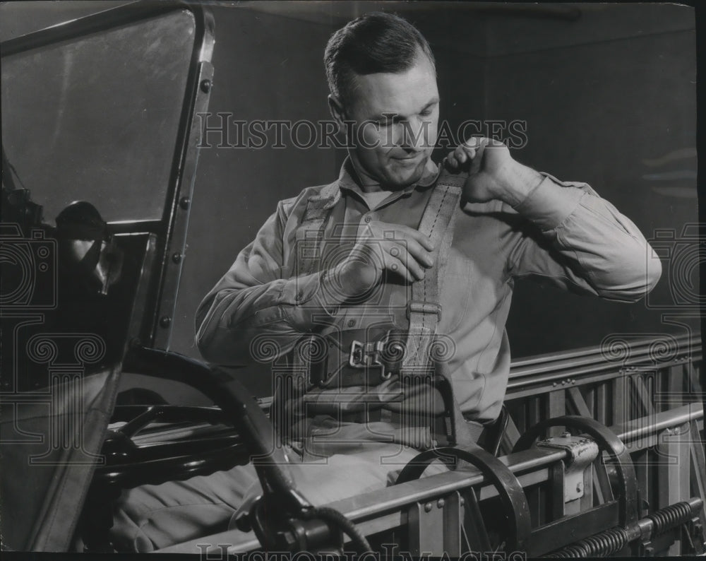 1956 Press Photo Fireman adjusting new safety belt on a ladder truck, Milwaukee - Historic Images