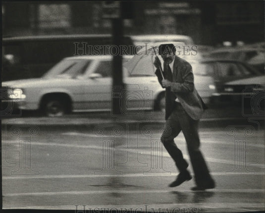 1980 Press Photo Man with umbrella running in the rain, Milwaukee - mjb42898 - Historic Images
