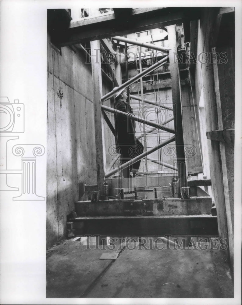 1964 Press Photo Eugene Genz stands inside steel tower of Greyhound building, WI - Historic Images