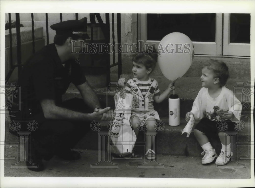 1993 Press Photo Officer Kevin Obrenski speaks young family in Milwaukee - Historic Images