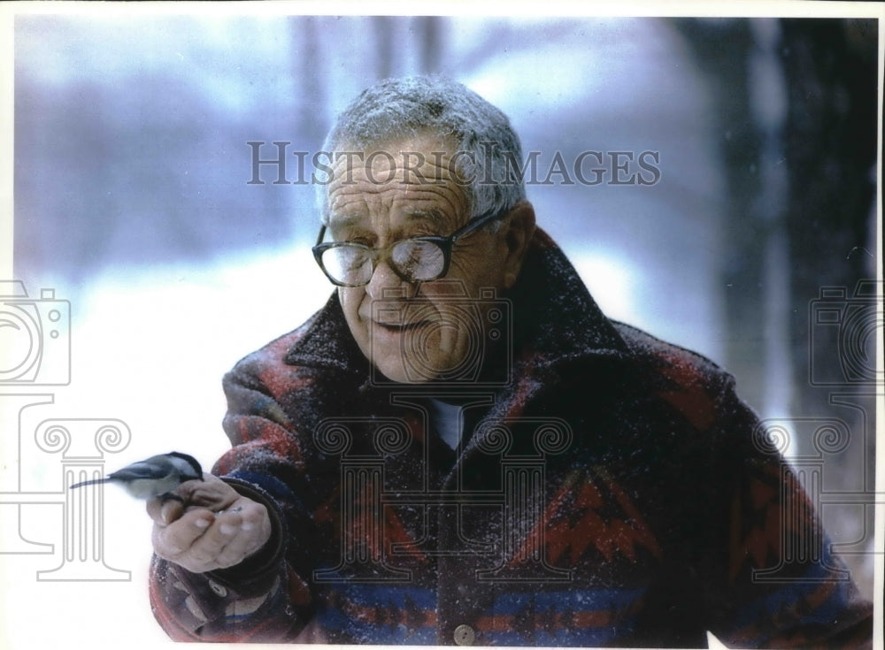 1994 Press Photo Martin Hanson, Wisconsin resort owner, hand feeds a bird, WI - Historic Images