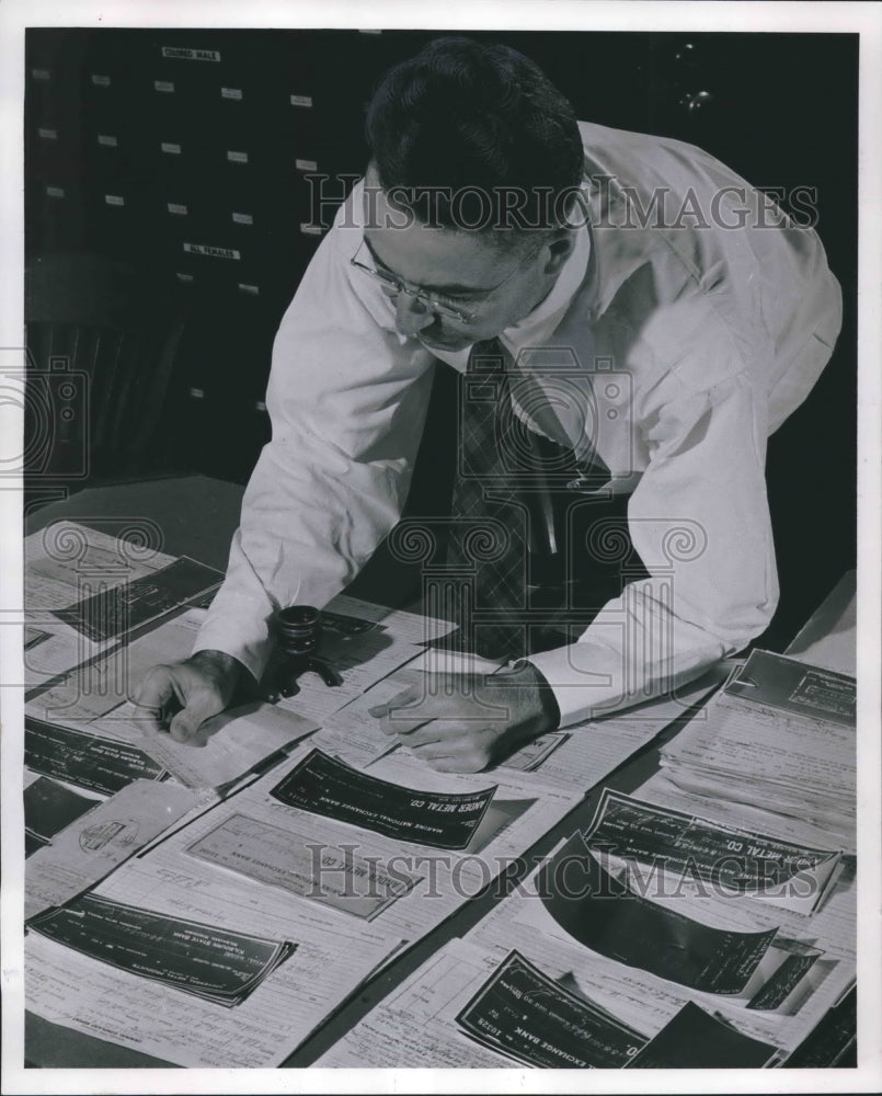 1954 Press Photo Orville Livingston inspecting bogus checks from case, Milwaukee- Historic Images