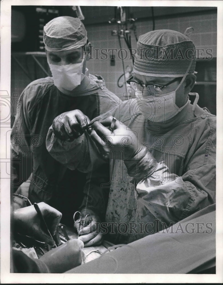 1970 Press Photo Dr. Johnson prepares to suture a vein graft into place. - Historic Images