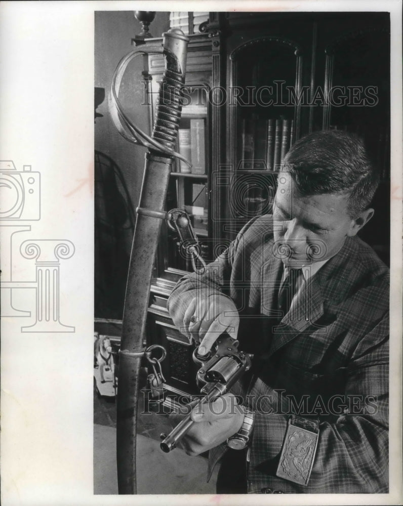 1967 Press Photo Harry Anderson, checks revolver used in civil war, Milwaukee. - Historic Images