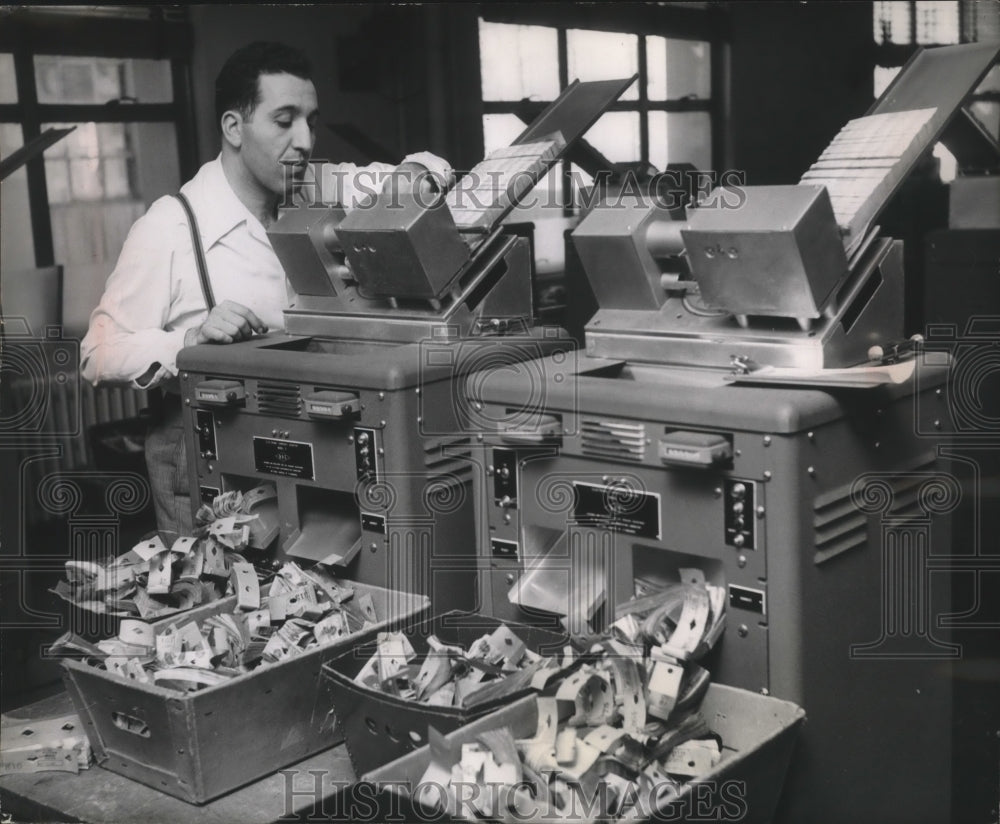 1952 Man uses electronic counters for stacks of perforated bills.-Historic Images