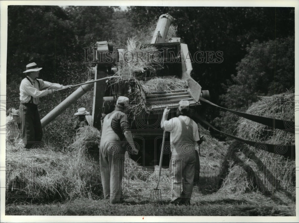 1993 Press Photo Character actors load wheat into an antique threshing machine - Historic Images