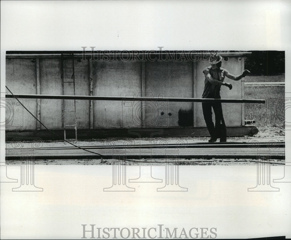 1978 Press Photo Worker tosses lengths of pipe from well at Exxon field, Texas - Historic Images