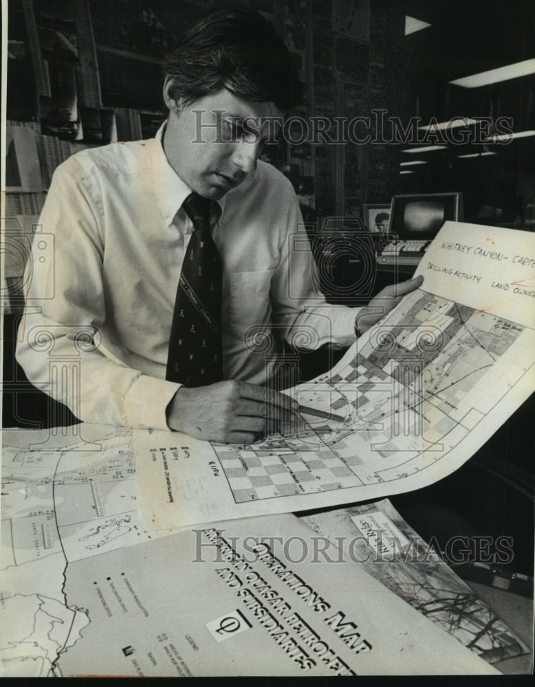 1981 Press Photo Howard Coleman looks over oil-field maps in Milwaukee - Historic Images