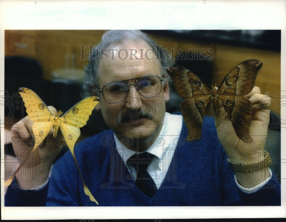 1993 Press Photo Phil Holzbauer, holds up moths from different countries - Historic Images