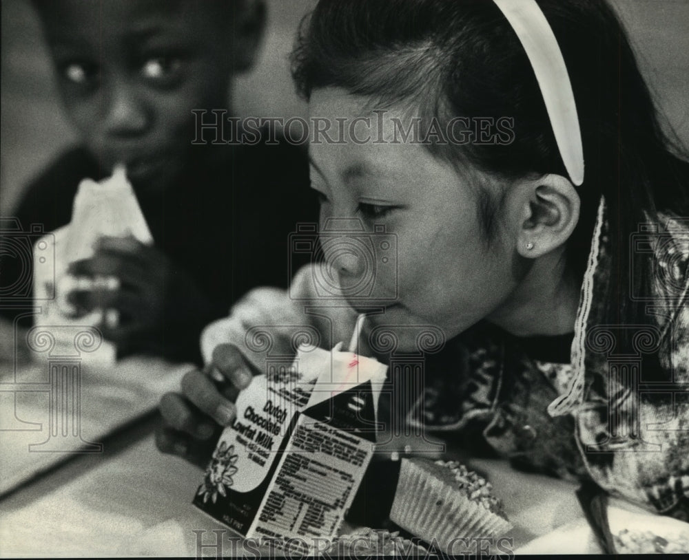 1991 Press Photo Trazel Lee, classmate sipping chocolate milk, lunch, Milwaukee.-Historic Images