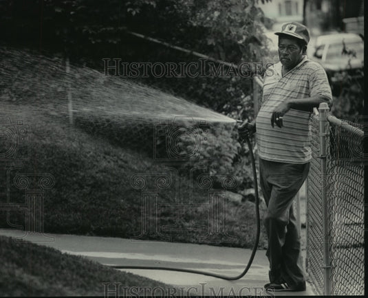 1984 Press Photo Theodore Fancher watering his lawn off Center Street, Milwaukee - Historic Images