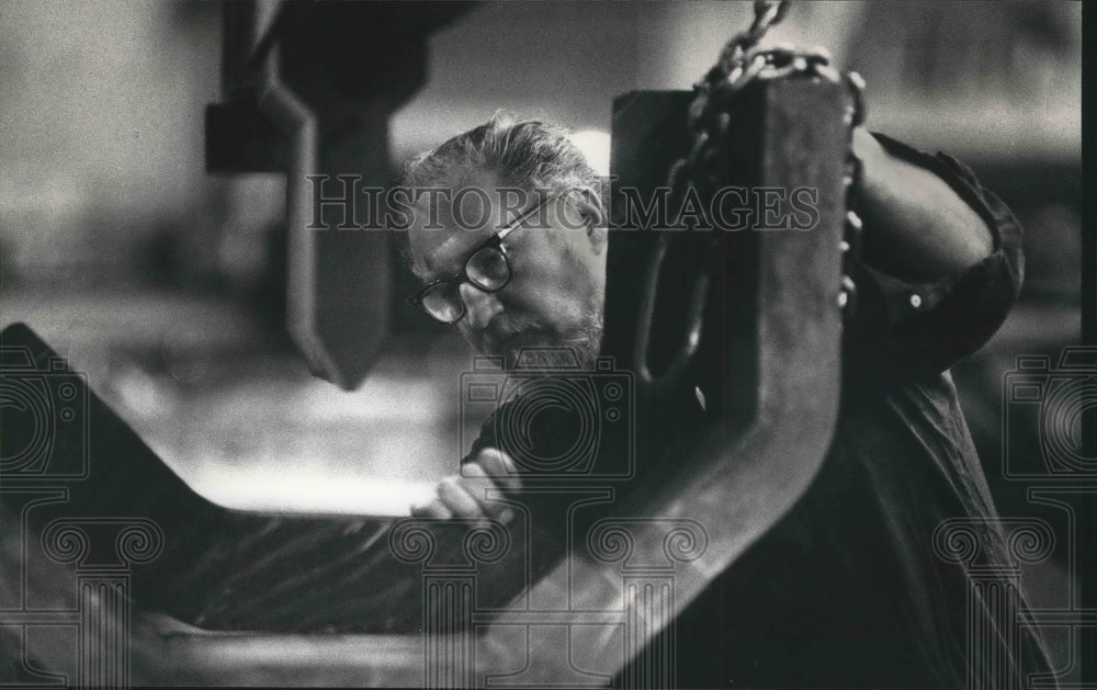 1991 Press Photo Bob Menke examines steel plate made at Harnischfeger Corp. - Historic Images