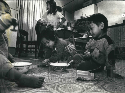 1992 Milwaukee Hmong Children eat on floor to make room for guests - Historic Images